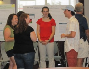 Some students from the 2012 REU show off their research at the symposium.