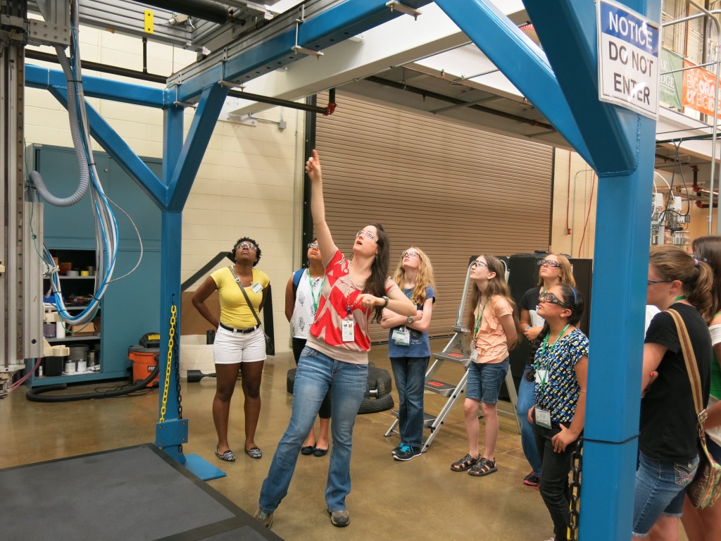 Amy Elliott (center, red shirt) shows the girls a 3D printer that's large enough to print a human-sized chair.