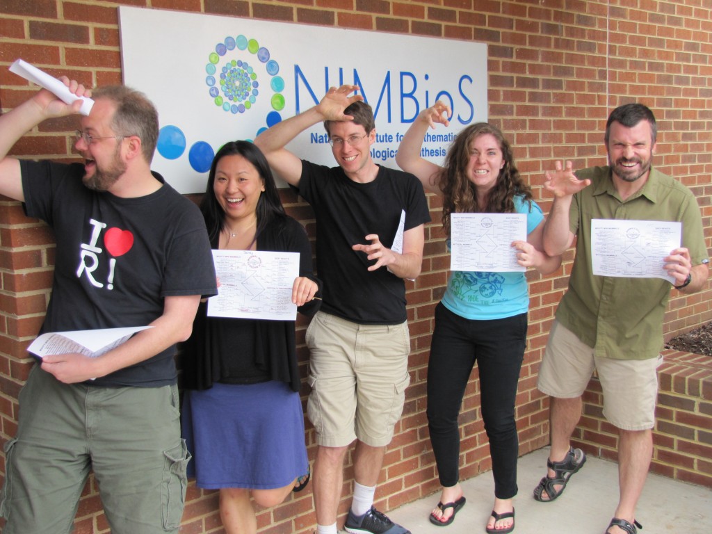 NIMBioS Postdocs and staff imitate the animal they chose to win while displaying their March Mammal Madness 2015 brackets